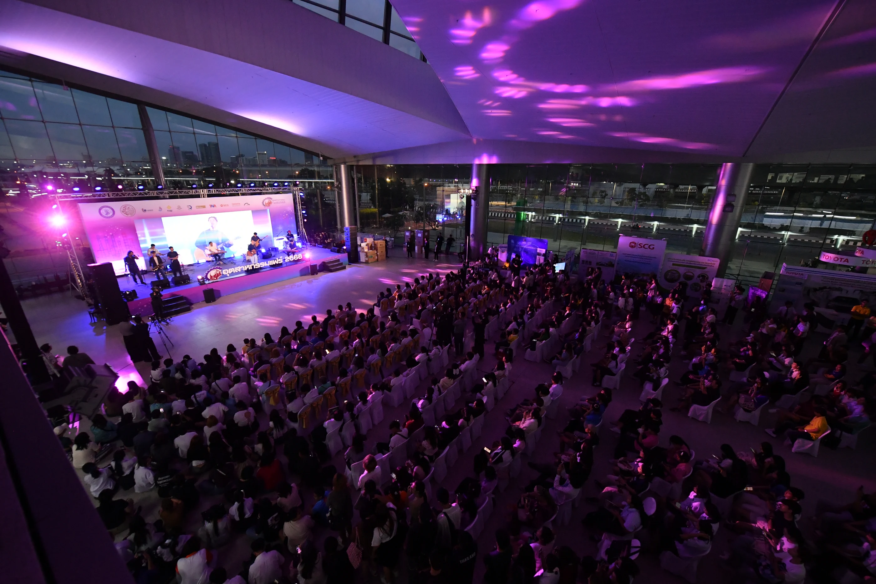 งานอุตสาหกรรมแฟร์ 2025 ห้องจัดงานเต็มไปด้วยผู้ร่วมงานใต้แสงเวทีโทนม่วง